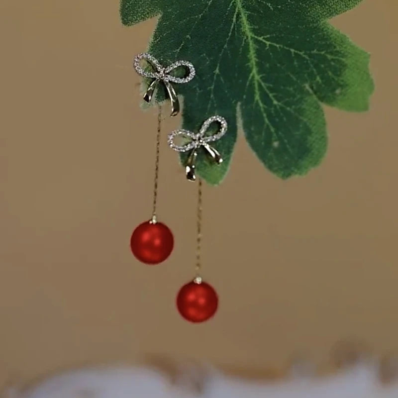 Angled view of the 14K Gold-Plated Elegant Zircon Bow Red Pearl Tassel Earrings