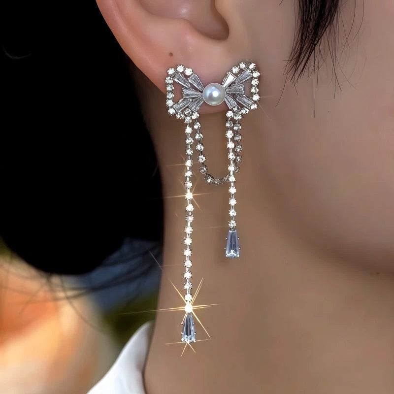 Model showcasing the dangle and style of the 14K Gold-Plated Elegant Zircon Bow Tassel Earrings