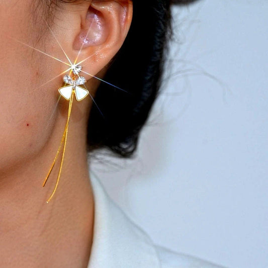 Model showcasing the dangle and style of the 14K Gold-Plated Elegant Zircon Bow Tassel Earrings