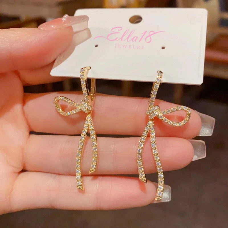 Model showcasing the dangle and style of the 14K Gold-Plated Elegant Zircon Bow Tassel Earrings