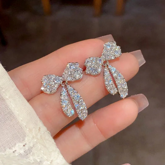 Model showcasing the dangle and style of the 14K Gold-Plated Elegant Zircon Bow Tassel Earrings