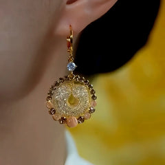 Model showcasing the dangle and style of the 14K Gold-Plated Elegant Zircon Brown Diamond Cat's Eye Stone Earrings