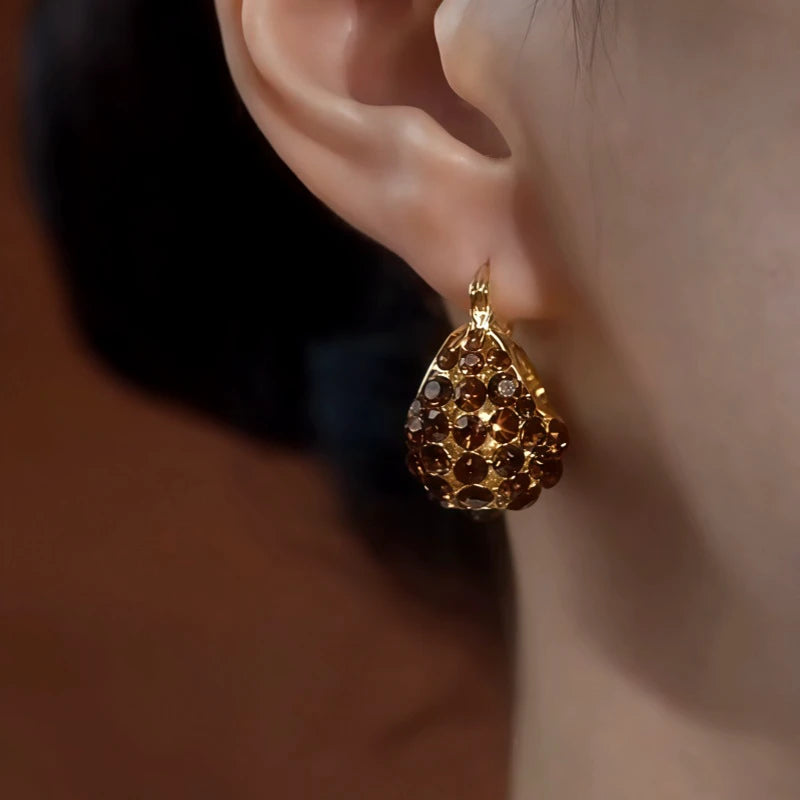Model showcasing the dangle and style of the 14K Gold-Plated Elegant Zircon Brown Diamond Handbag Earrings