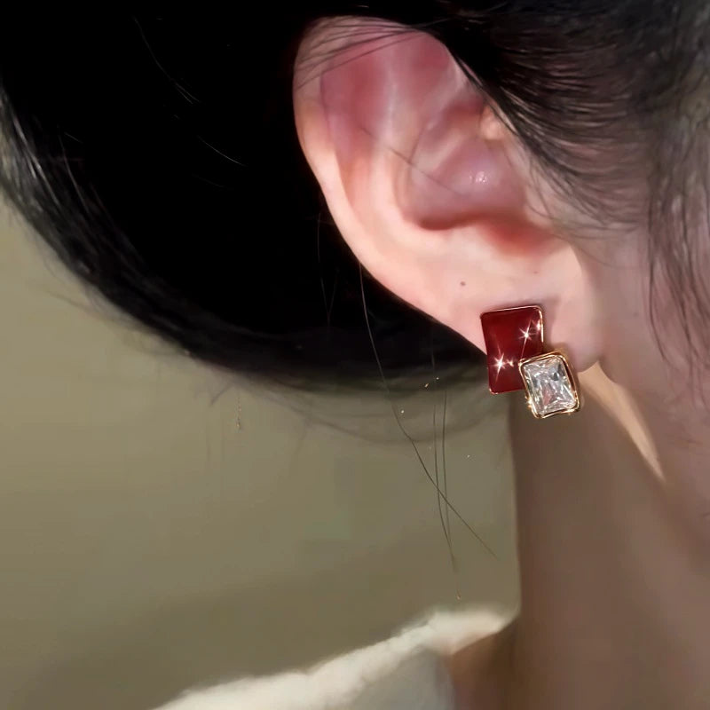 Model showcasing the dangle and style of the 14K Gold-Plated Elegant Zircon Burgundy Stud Earrings