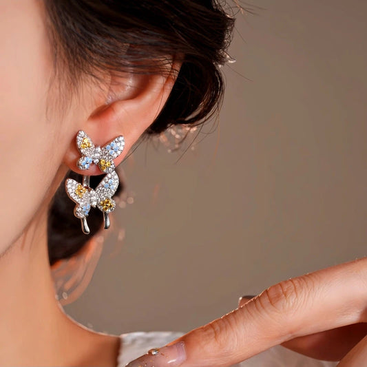 Model showcasing the dangle and style of the 14K Gold-Plated Elegant Zircon Butterfly Jacket Earrings