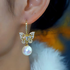Model showcasing the dangle and style of the 14K Gold-Plated Elegant Zircon Butterfly Mabe Pearl Ear Hooks