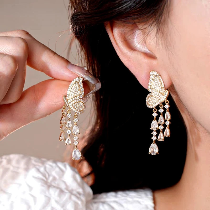 Model showcasing the dangle and style of the 14K Gold-Plated Elegant Zircon Butterfly Tassel Earrings