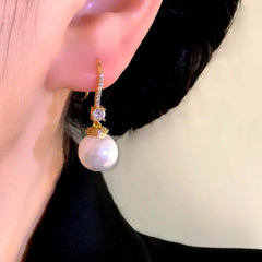 Model showcasing the dangle and style of the 14K Gold-Plated Elegant Zircon Cat's Eye Bead Earrings