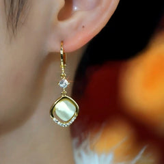 Model showcasing the dangle and style of the 14K Gold-Plated Elegant Zircon Cat's Eye Mountain Stone Earrings