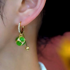 Model showcasing the dangle and style of the 14K Gold-Plated Elegant Zircon Cat's Eye Stone Ball Tassel Earrings