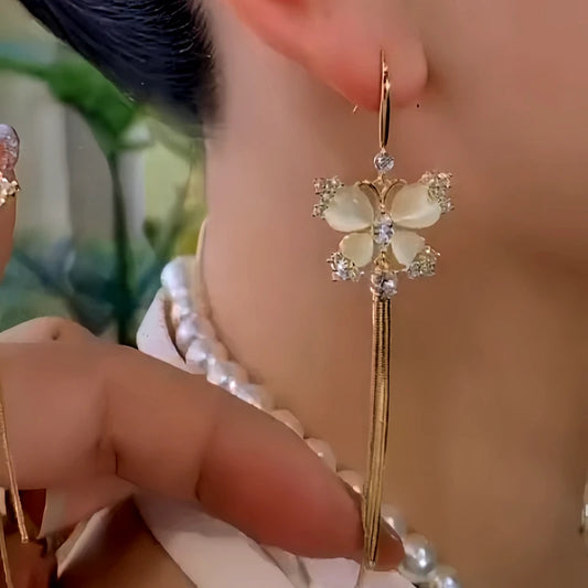 Model showcasing the dangle and style of the 14K Gold-Plated Elegant Zircon Cat's Eye Stone Butterfly Ear Hook Tassel Earrings