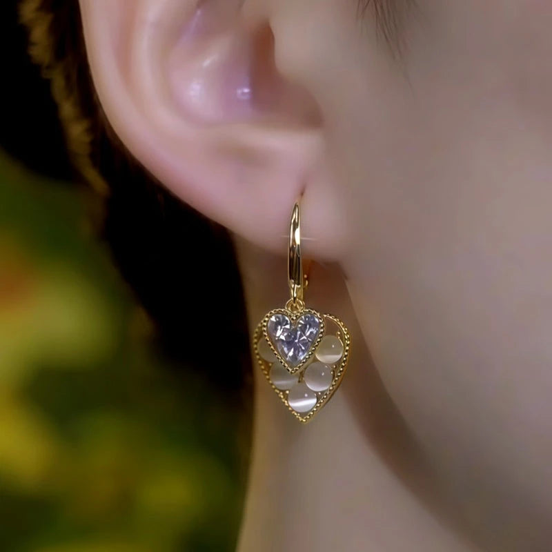 Model showcasing the dangle and style of the 14K Gold-Plated Elegant Zircon Cat's Eye Stone Double-Heart Earrings