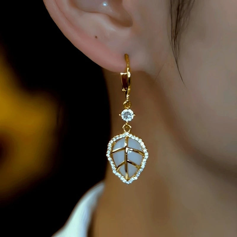 Model showcasing the dangle and style of the 14K Gold-Plated Elegant Zircon Cat's Eye Stone Leaf Earrings
