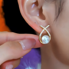 Model showcasing the dangle and style of the 14K Gold-Plated Elegant Zircon Cross Pearl Earrings