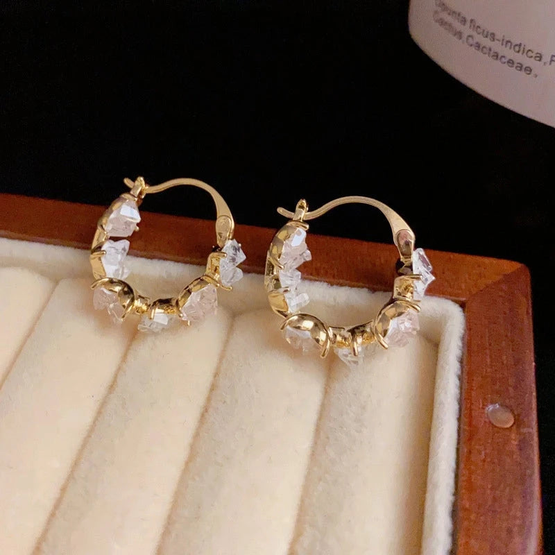 Close-up detail of the sparkling zircons and plating on the Heart Hoop Earrings