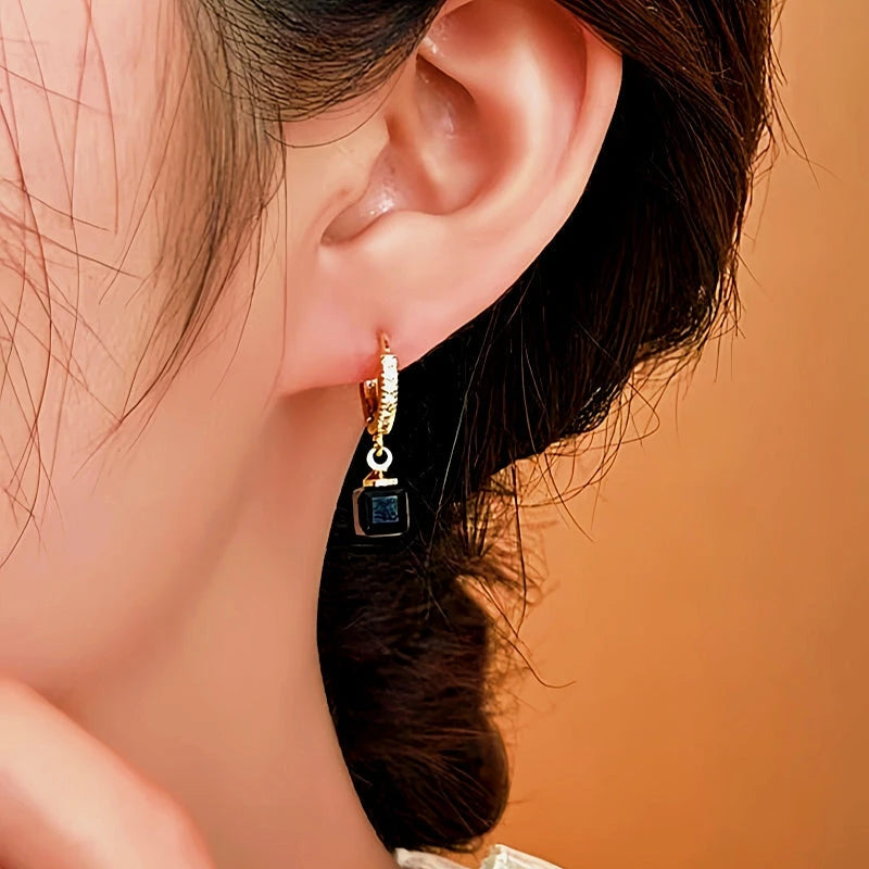 Model showcasing the dangle and style of the 14K Gold-Plated Elegant Zircon Cube Earrings