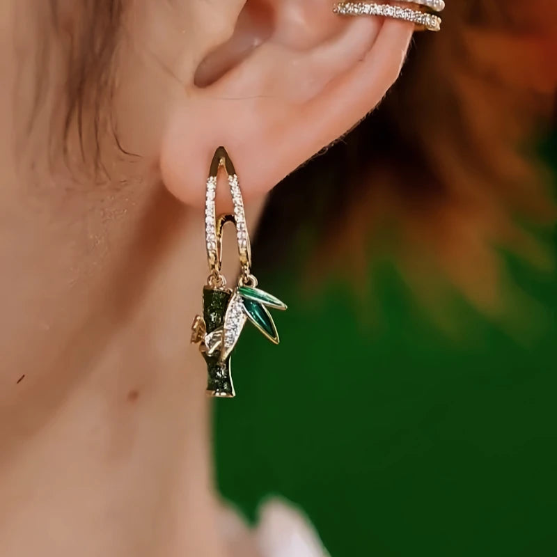 Model showcasing the dangle and style of the 14K Gold-Plated Elegant Zircon Diamond Bamboo Earrings