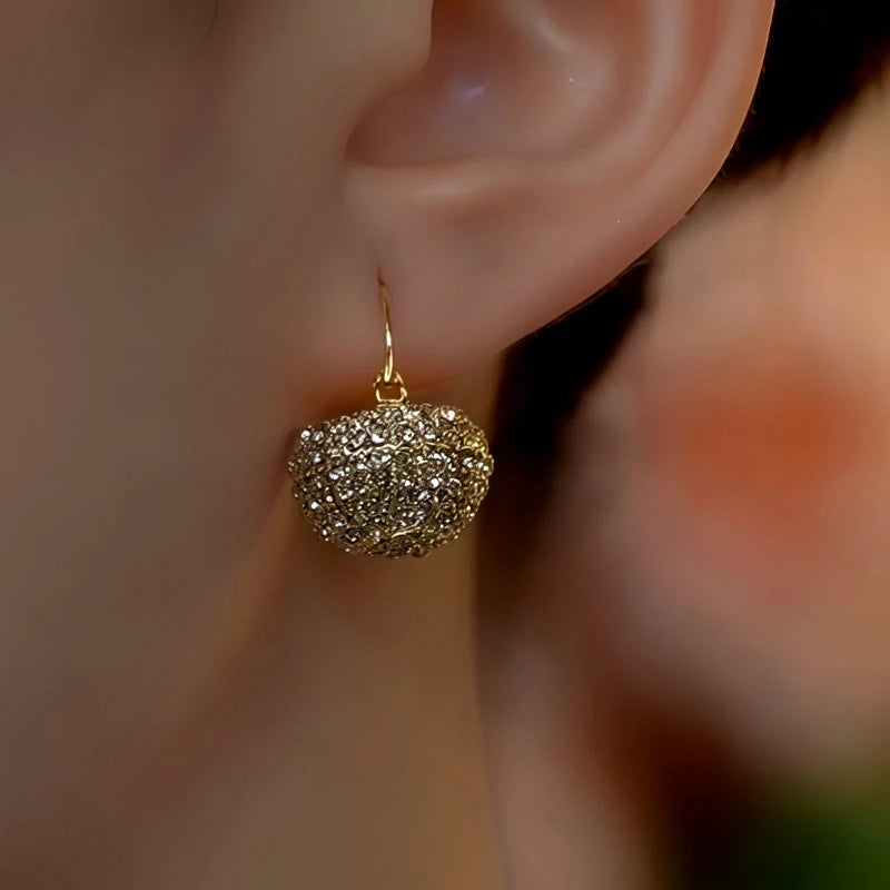 Model showcasing the dangle and style of the 14K Gold-Plated Elegant Zircon Diamond Basket Earrings