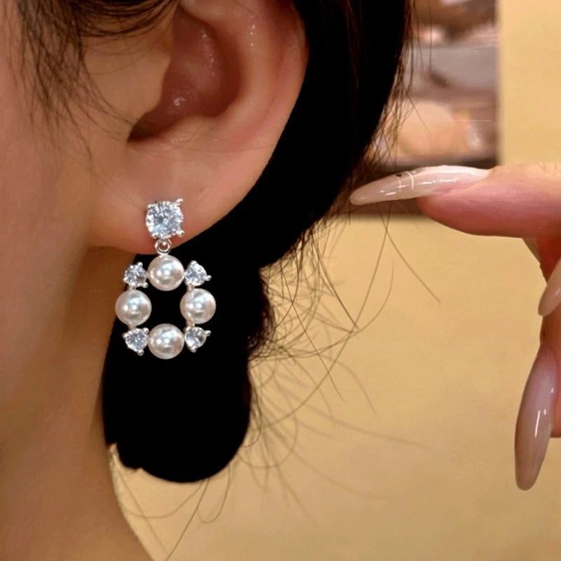 Model showcasing the dangle and style of the 14K Gold-Plated Elegant Zircon Diamond Bead Earrings