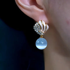 Model showcasing the dangle and style of the 14K Gold-Plated Elegant Zircon Diamond Cat's Eye Bead Tassel Earrings
