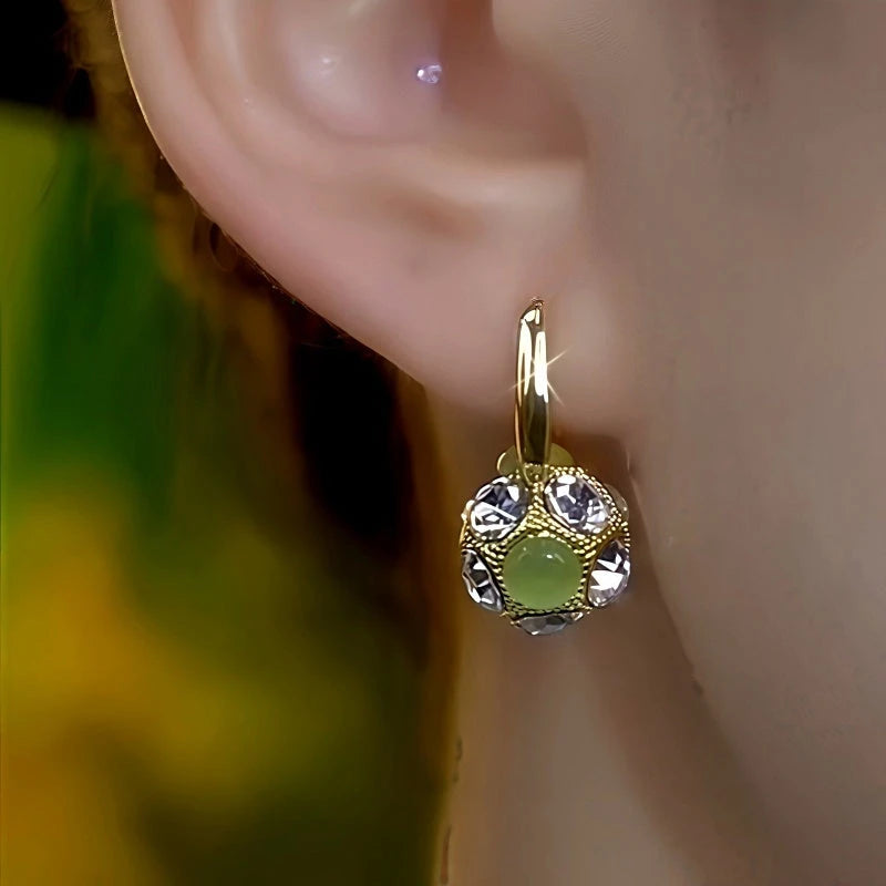 Model showcasing the dangle and style of the 14K Gold-Plated Elegant Zircon Diamond Cat's Eye Stone Ball Earrings