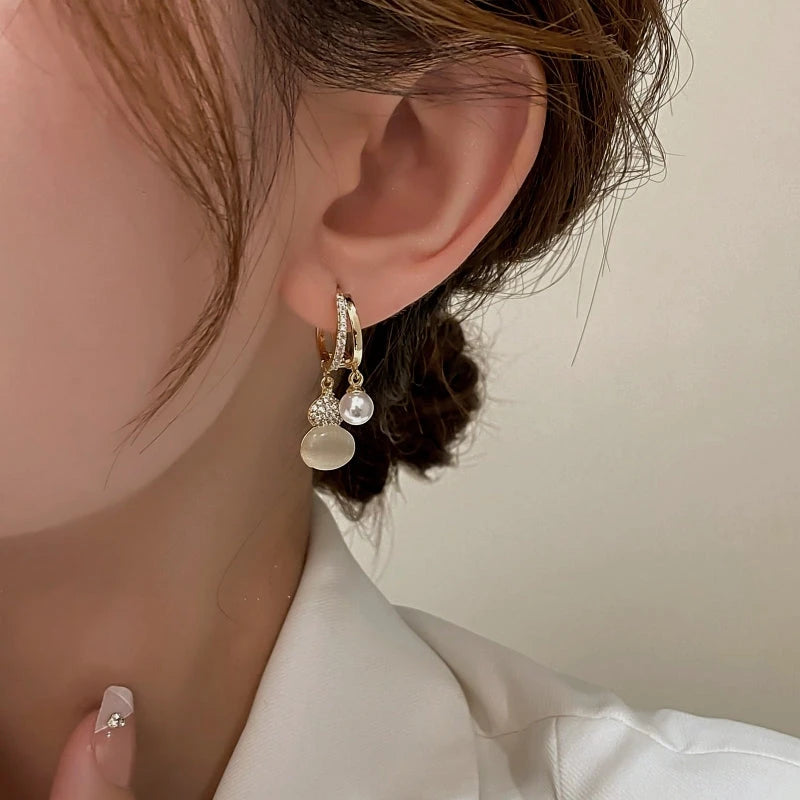 Model showcasing the dangle and style of the 14K Gold-Plated Elegant Zircon Diamond Cat's Eye Stone Gourd Earrings