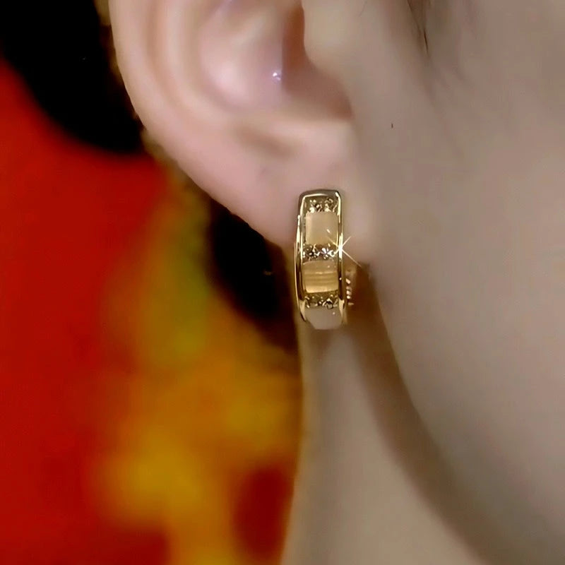 Model showcasing the dangle and style of the 14K Gold-Plated Elegant Zircon Diamond Cat's Eye Stone Hoop Earrings