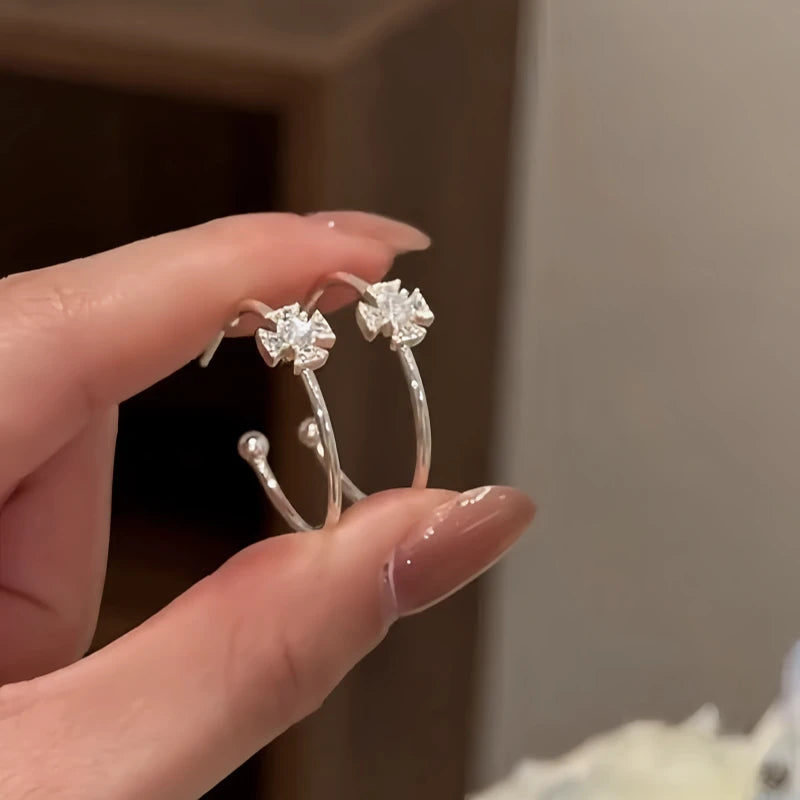 Model showcasing the dangle and style of the 14K Gold-Plated Elegant Zircon Diamond Cross Hoop Earrings