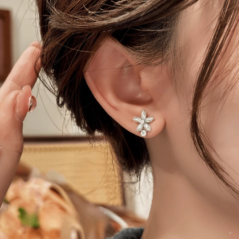 Model showcasing the dangle and style of the 14K Gold-Plated Elegant Zircon Diamond Flower Stud Earrings