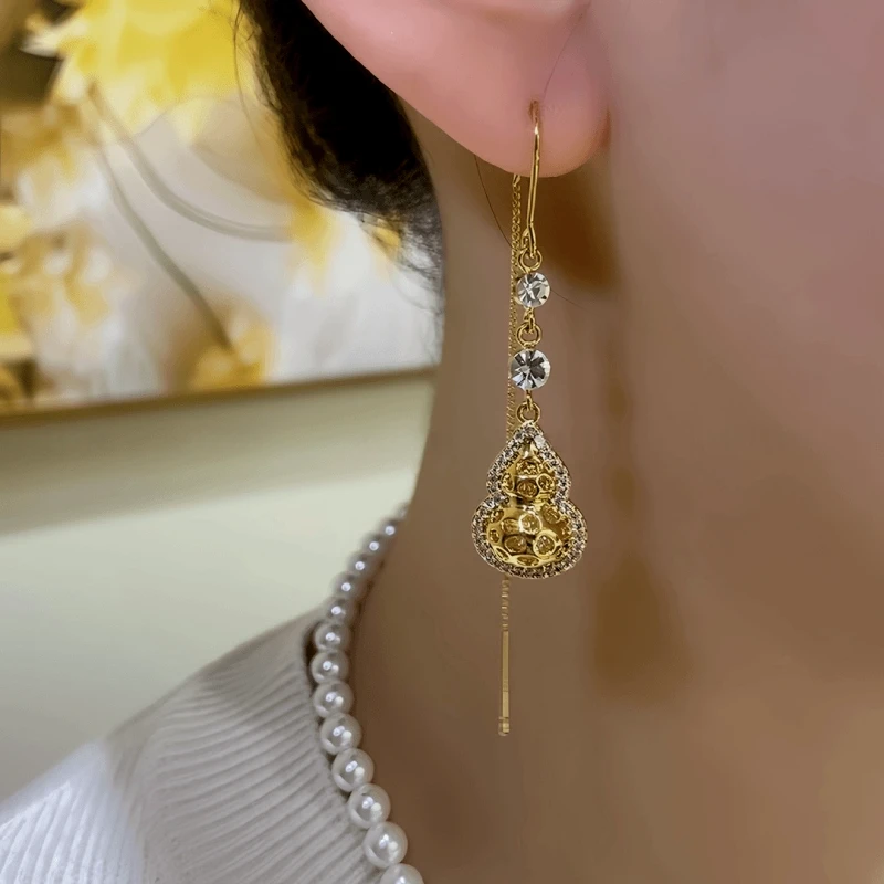 Model showcasing the dangle and style of the 14K Gold-Plated Elegant Zircon Diamond Gourd Threader Earrings