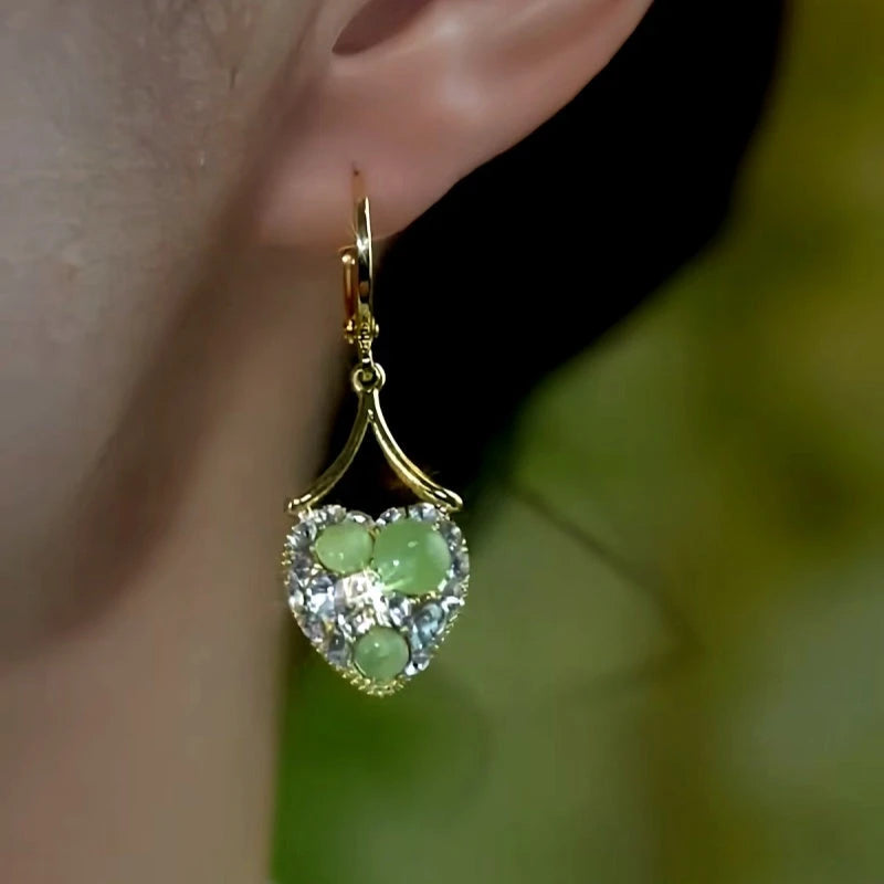 Model showcasing the dangle and style of the 14K Gold-Plated Elegant Zircon Diamond Green Cat's Eye Stone Heart Earrings
