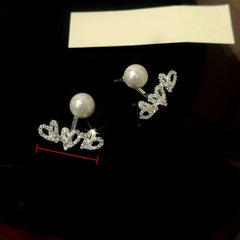 Model showcasing the dangle and style of the 14K Gold-Plated Elegant Zircon Diamond Heart Pearl Jacket Earrings