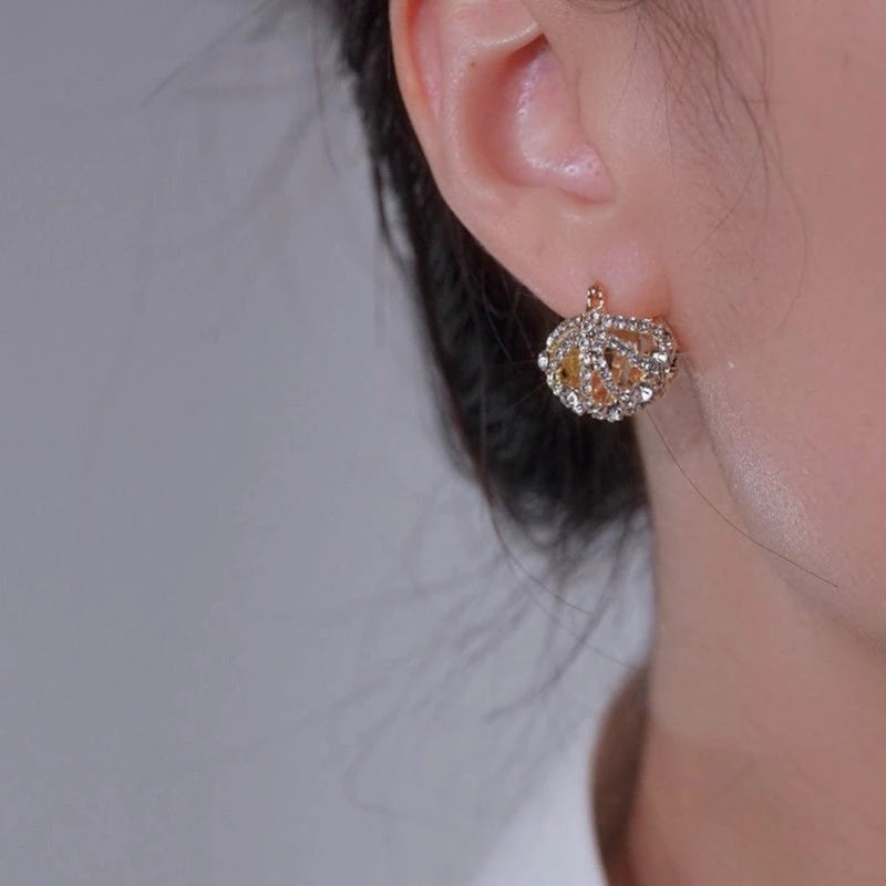 Model showcasing the dangle and style of the 14K Gold-Plated Elegant Zircon Diamond Hollow Cradle Earrings
