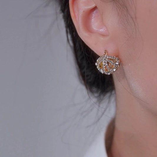 Model showcasing the dangle and style of the 14K Gold-Plated Elegant Zircon Diamond Hollow Cradle Earrings