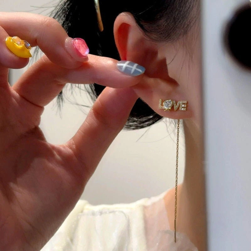 Model showcasing the dangle and style of the 14K Gold-Plated Elegant Zircon Diamond LOVE Threader Earrings