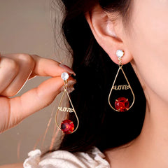 Model showcasing the dangle and style of the 14K Gold-Plated Elegant Zircon Diamond Love Letter Tassel Earrings