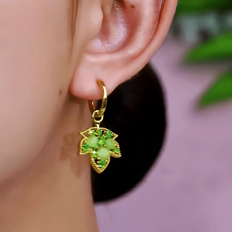 Model showcasing the dangle and style of the 14K Gold-Plated Elegant Zircon Diamond Maple Leaf Earrings