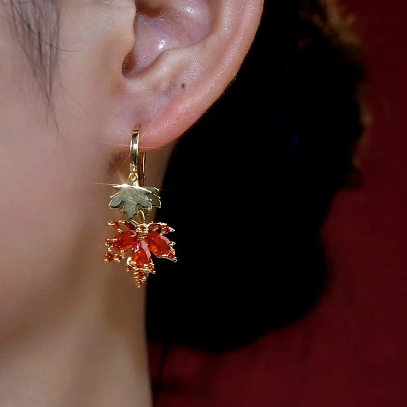 Model showcasing the dangle and style of the 14K Gold-Plated Elegant Zircon Diamond Maple Leaf Tassel Earrings
