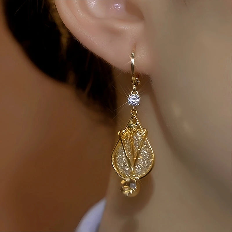 Model showcasing the dangle and style of the 14K Gold-Plated Elegant Zircon Diamond Mesh Tulip Earrings