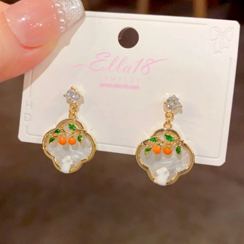 Model showcasing the dangle and style of the 14K Gold-Plated Elegant Zircon Diamond Oil Drop Four-Leaf Persimmon Earrings