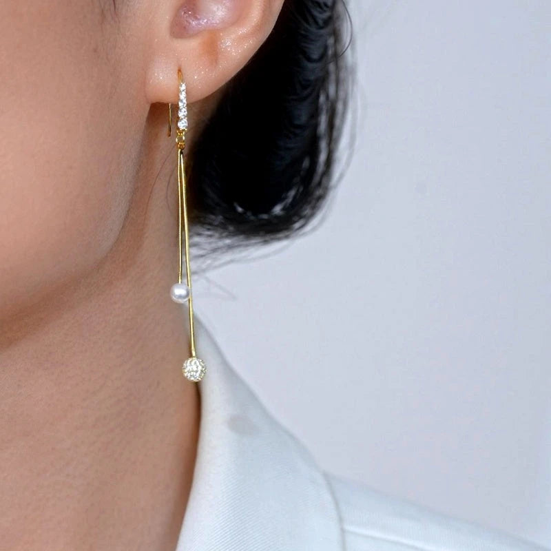 Model showcasing the dangle and style of the 14K Gold-Plated Elegant Zircon Diamond Pearl Ball Ear Hooks