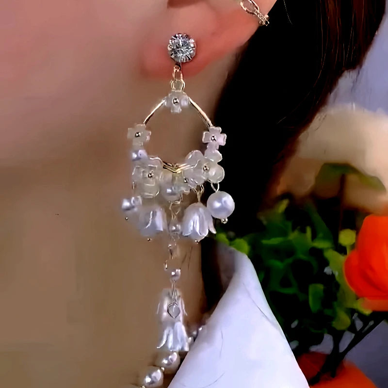 Model showcasing the dangle and style of the 14K Gold-Plated Elegant Zircon Diamond Pearl Lily Tassel Earrings