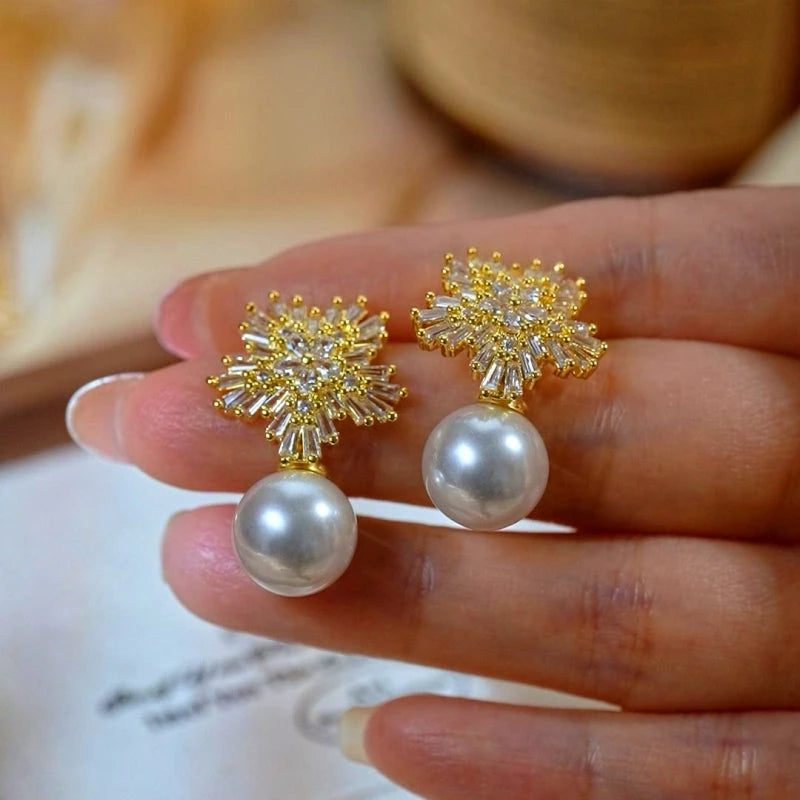 Model showcasing the dangle and style of the 14K Gold-Plated Elegant Zircon Diamond Snowflake Pearl Earrings
