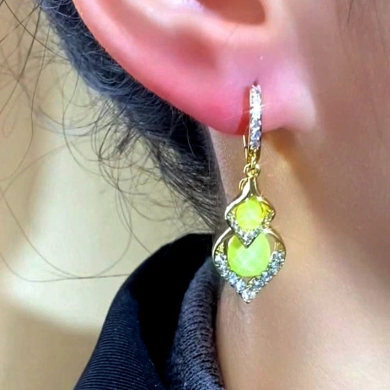 Model showcasing the dangle and style of the 14K Gold-Plated Elegant Zircon Double-Leaf Earrings