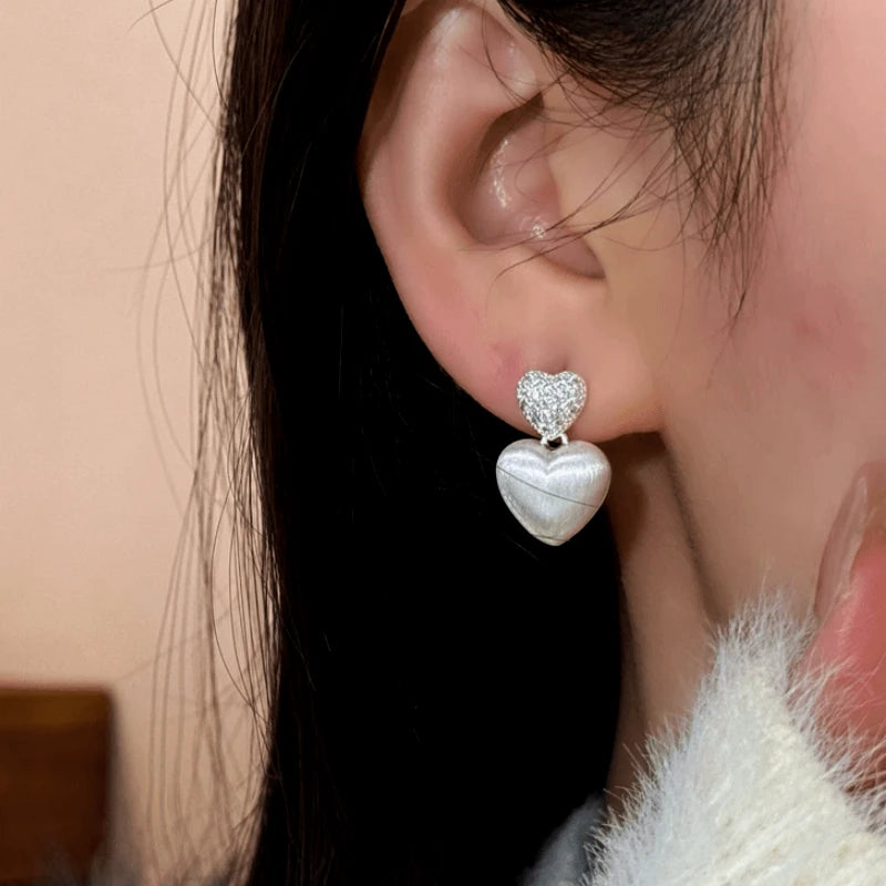 Close-up detail of the sparkling zircons and plating on the Double Heart Dangle Earrings