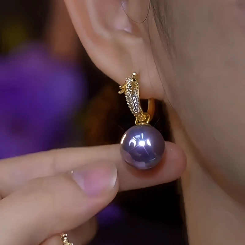 Model showcasing the dangle and style of the 14K Gold-Plated Elegant Zircon Dragon Purple Pearl Earrings