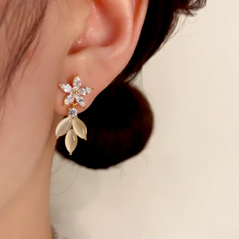 Model showcasing the dangle and style of the 14K Gold-Plated Elegant Zircon Flower Cat's Eye Leaf Earrings