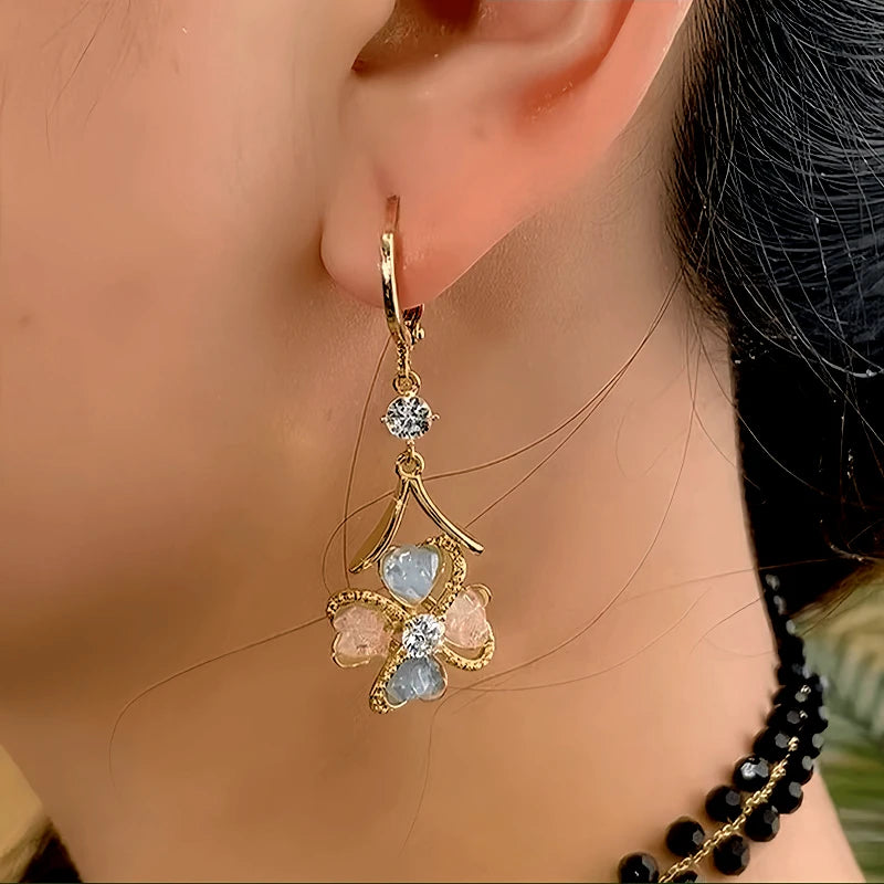 Model showcasing the dangle and style of the 14K Gold-Plated Elegant Zircon Flower Earrings
