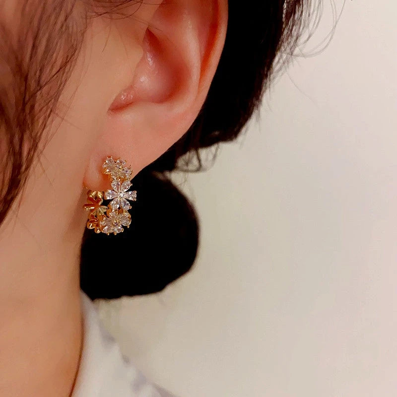 Model showcasing the dangle and style of the 14K Gold-Plated Elegant Zircon Flower Hoop Earrings