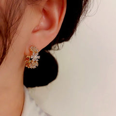 Model showcasing the dangle and style of the 14K Gold-Plated Elegant Zircon Flower Hoop Earrings